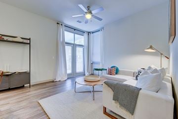 San Antonio apartment for rent - A living room with a white couch and a ceiling fan.