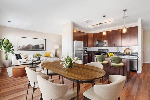 West Hempstead apartment for rent - a living and dining room area with a kitchen in the background and a large table in the at West 130, West Hempstead New York