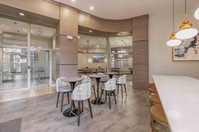 Bayonne apartment for rent - A modern dining area with a glass wall and a curved ceiling at Harbor Pointe Apartments, Bayonne, NJ, 07002