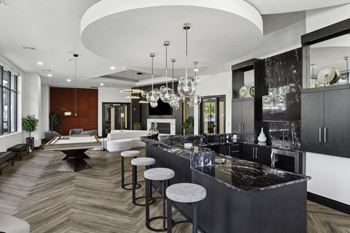 A large kitchen with marble counter tops and bar stools