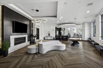 A large living room with a white couch and a television