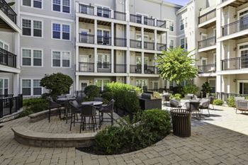 An outdoor courtyard with tables and chairs at an apartment building