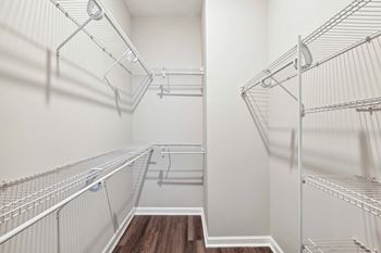 The walk in closet of a bedroom with mirrored closets