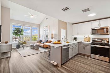 A living room with a kitchen and a dining room