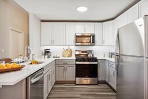 Hempstead apartment for rent - a kitchen with white cabinets and stainless steel appliances at Metro 303, Hempstead