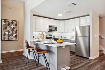 A kitchen with a island and stainless steel refrigerator