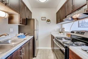 Lakewood apartment for rent - A kitchen with a stove top oven and a refrigerator at Mountain Vista Apartments, Lakewood