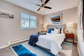 Lakewood apartment for rent - A bedroom with a bed, a ceiling fan, and a rug at Mountain Vista Apartments, Lakewood, Colorado