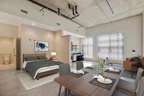 Denver apartment for rent - A modern bedroom with a large bed and a dining area with a table set for four at RiDE at RiNo Apartments, Denver 80216