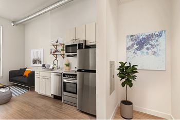 A modern kitchen with a refrigerator, oven, and sink.