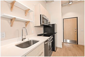 A kitchen with a sink, stove, and microwave.