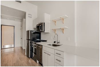 A kitchen with white cabinets and a black stove top oven.