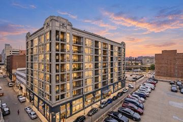 Baltimore apartment for rent - A large building with many windows is surrounded by a parking lot.