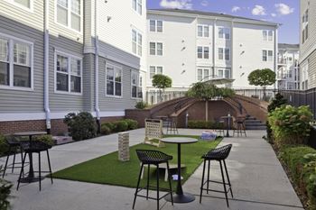 A patio with tables and chairs in front of a building