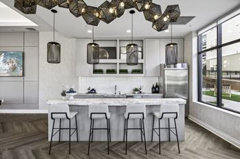 A kitchen with a marble counter top and bar stools