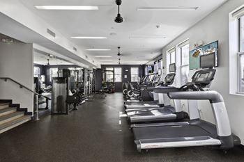 A gym with treadmills and other cardio equipment in a building