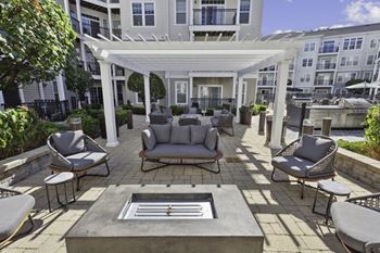 A patio with couches and chairs and a fire pit