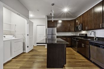 A kitchen with dark wood cabinets and white appliances