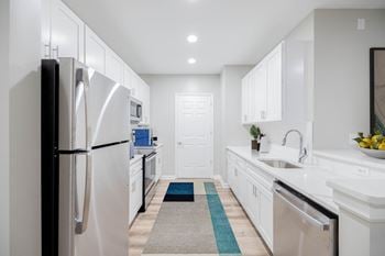 A modern kitchen with white cabinets and a black refrigerator