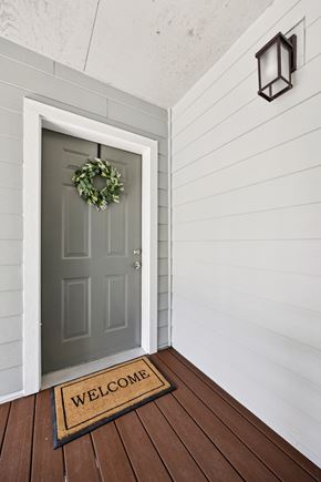 Keizer apartment for rent - A grey door with a wreath and a welcome mat on a wooden floor.
