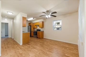 Aloha apartment for rent - A kitchen with wooden cabinets and a ceiling fan.
