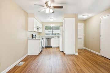 Keizer apartment for rent - A kitchen with white cabinets and a wooden floor.