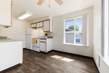 Canby apartment for rent - A kitchen with white cabinets and a window overlooking a building.