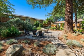 Beaverton apartment for rent - a patio with a table and chairs in front of a building