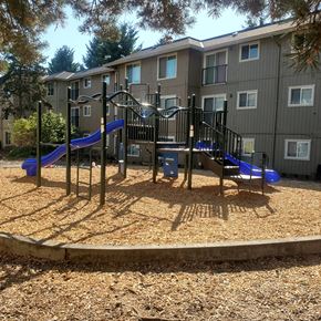 Portland apartment for rent - a playground with a blue slide in front of an apartment building