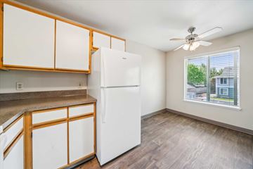 Milwaukie apartment for rent - A white refrigerator in a kitchen with wooden cabinets.