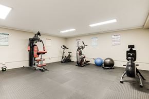 Beaverton apartment for rent - a home gym with exercise equipment and weights on the wall