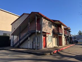 Hillsboro apartment for rent - A building with a red roof and a staircase leading to the entrance.