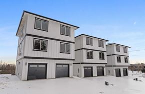 Salem apartment for rent - A row of modern houses with garages are built on a snowy lot.