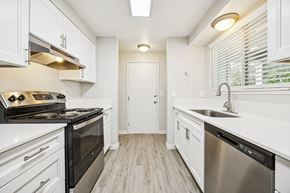 Salem triplex for rent - A modern kitchen with white cabinets and stainless steel appliances.