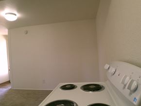 Seaside apartment for rent - A white stove with four burners is in a room with white walls.