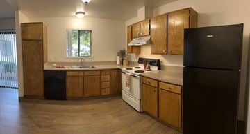 Scappoose apartment for rent - A kitchen with wooden cabinets and a black refrigerator.