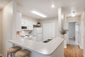 Beaverton apartment for rent - A kitchen with white cabinets and a countertop with two stools.