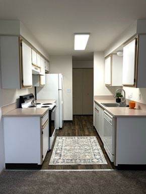 Keizer apartment for rent - A kitchen with white cabinets and a rug on the floor.