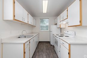 Aloha apartment for rent - A kitchen with white cabinets and appliances.