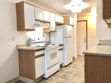 Gresham apartment for rent - a kitchen with white appliances and wooden cabinets