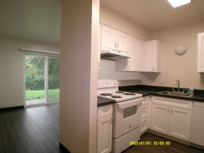 Hammond apartment for rent - A kitchen with white cabinets and black countertops.