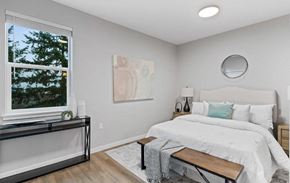 Salem apartment for rent - A bedroom with a large bed and a window overlooking a tree.