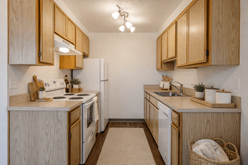Salem apartment for rent - A kitchen with wooden cabinets and white appliances.