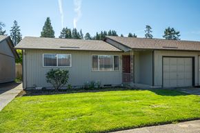Salem apartment for rent - A house with a garage and a small tree in the front yard.