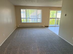 Aloha apartment for rent - A room with a carpeted floor and a sliding glass door leading to a balcony.