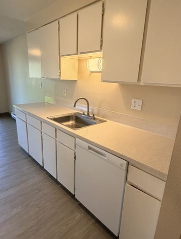 Aloha apartment for rent - A kitchen with white cabinets and a sink.