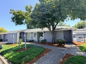 Aloha apartment for rent - A house with a grey roof and a tree in front of it.