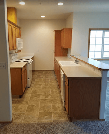 Beaverton apartment for rent - A kitchen with brown cabinets and a tiled floor.