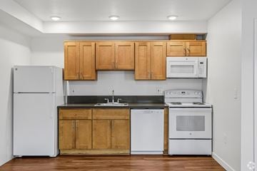 Portland apartment for rent - A kitchen with wooden cabinets and white appliances.