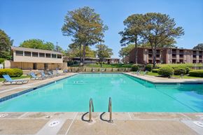 College Park apartment for rent - A large swimming pool with a diving board in the middle of it.